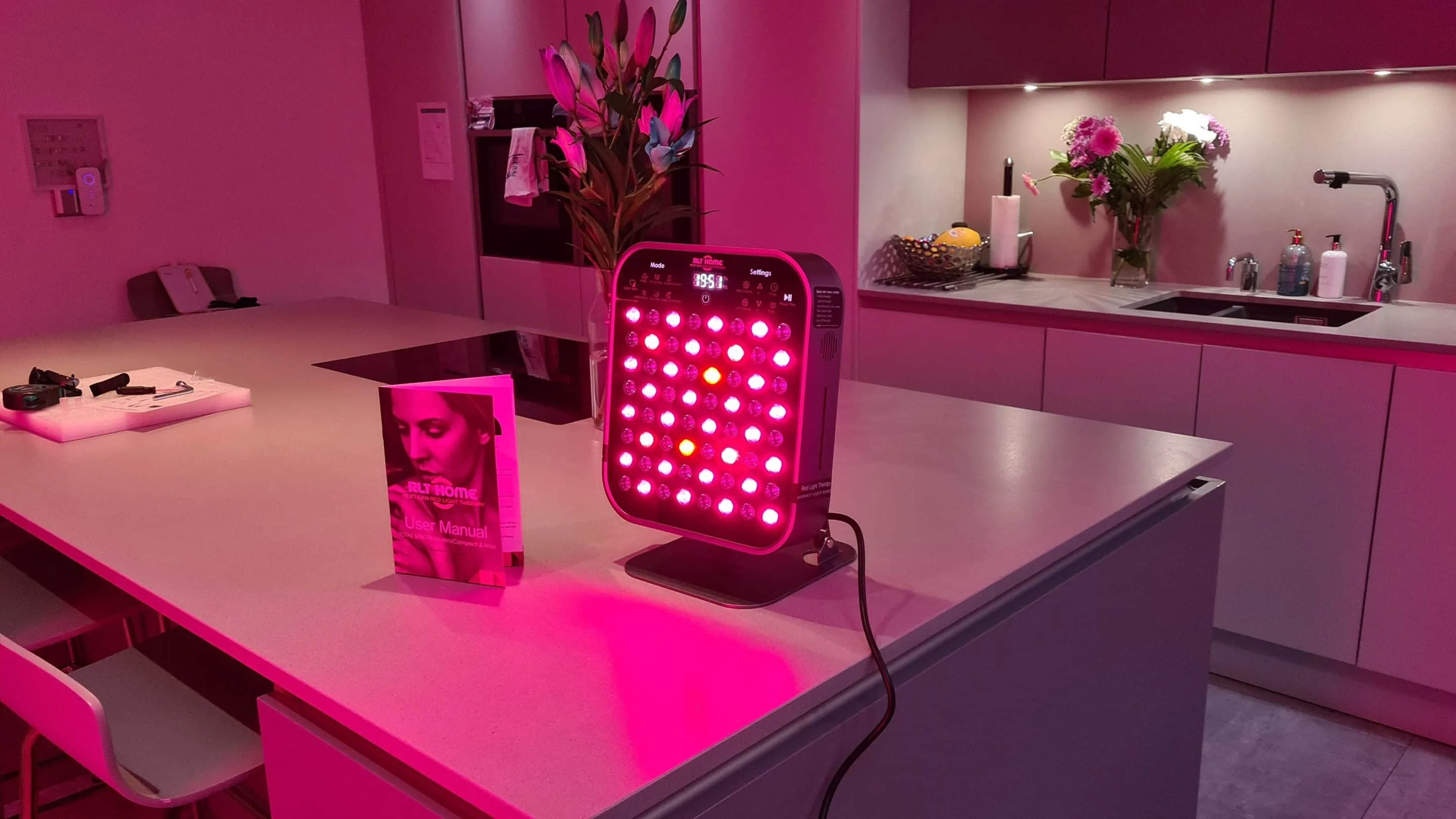 Total Spectrum MINI red light therapy device used at home on a kitchen counter